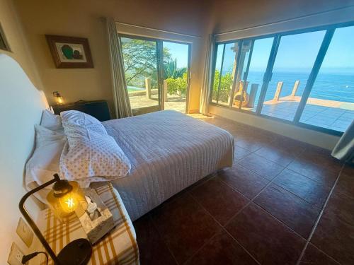 a bedroom with a bed and a view of the ocean at The Sanctuary above Lo De Marcos in Lo de Marcos