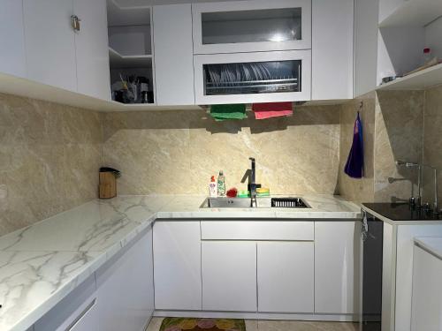 a kitchen with white cabinets and a sink at The Palm Phu Quoc Resort & Villa in Phú Quốc