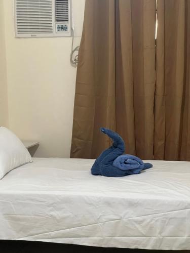 a blue stuffed animal is sitting on a bed at Studio 7 in Manila