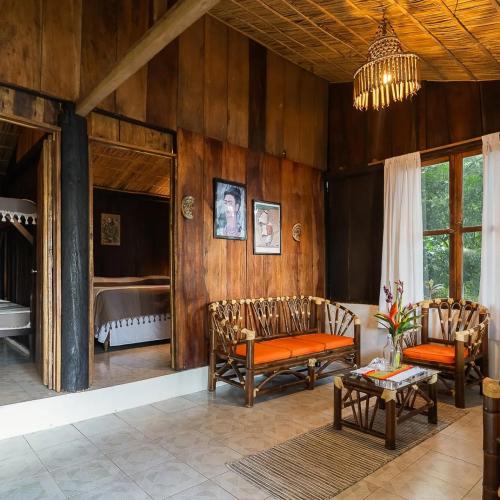 a living room with wooden walls and a chandelier at Los Amigos Ecoturismo y Reserva Natural in Catemaco