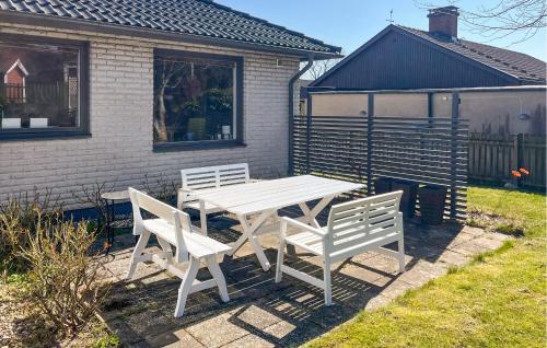 a white picnic table and two chairs in a yard at Lovely Home In Simrishamn With Wifi in Simrishamn