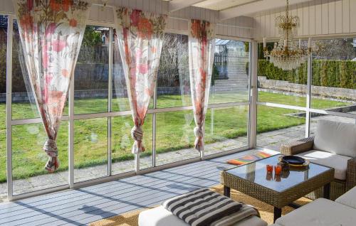 a living room with large windows and a couch at Lovely Home In Simrishamn With Wifi in Simrishamn