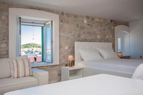 een witte slaapkamer met 2 bedden en een raam bij Apartments Dalmata in Krapanj