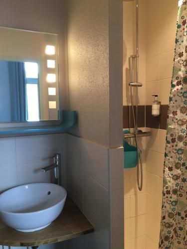 y baño con lavabo y espejo. en Hôtel Familial L'Ostréi en Arcachon