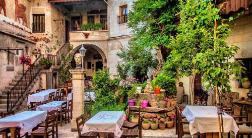 an outdoor patio with tables and chairs in a building at Sofa Hotel in Avanos