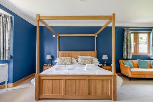 a bedroom with a canopy bed with blue walls at Manor House in Chesterfield