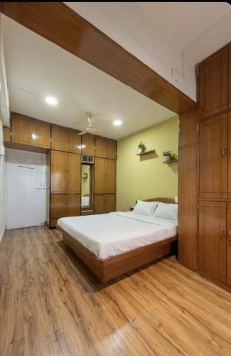 a bedroom with a large bed and wooden cabinets at Celestial crest in Pune