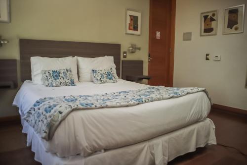 a bedroom with a large bed with blue pillows at Hotel Boutique 17 in Valparaíso