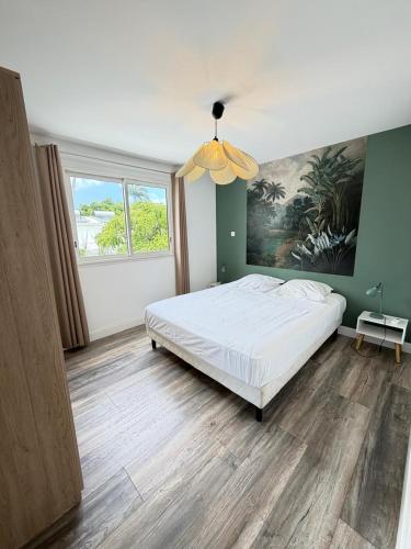 a bedroom with a bed and a large window at Le Papangue in Saint-Paul