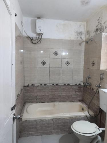 a bathroom with a bath tub and a toilet at 1 Bhk apartment kyle garden baga beech in Baga