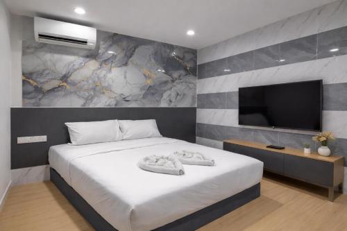 a bedroom with a large bed and a flat screen tv at ARK Port Dickson Seafront Hotel in Port Dickson