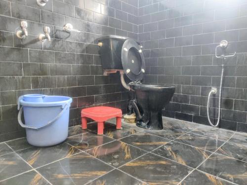 a dirty bathroom with a toilet and a bucket at Hotel T-Suru Leh in Leh