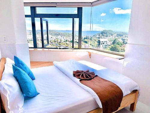 a bed in a room with a large window at Villa đà lạt Trung Nghĩa 1 in Ấp Ða Lợi