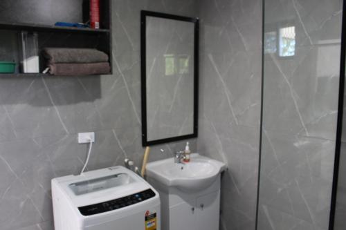a bathroom with a toilet and a sink and a mirror at Naikabula Villa in Lautoka