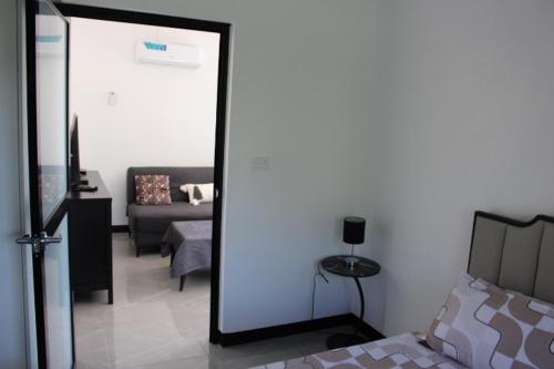 a bedroom with a bed and a living room at Naikabula Villa in Lautoka