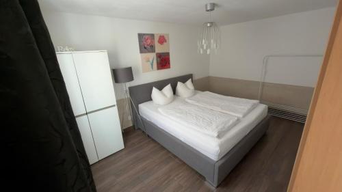 a bedroom with a bed with white sheets and pillows at Apartment Stabel 8,1 km von Europa Park in Kippenheim