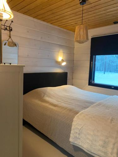 a bedroom with a white bed and a window at Lapin Unelma in Äkäslompolo