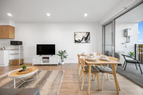 a living room with a table and chairs and a tv at Elevated 2BR & Sofa Bed Apartment in the Heart of Prospect in Prospect