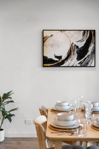 a dining room table with a painting on the wall at Elevated 2BR & Sofa Bed Apartment in the Heart of Prospect in Prospect