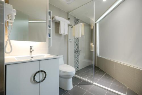 台中的住宿－香富大飯店，浴室配有卫生间、盥洗盆和淋浴。