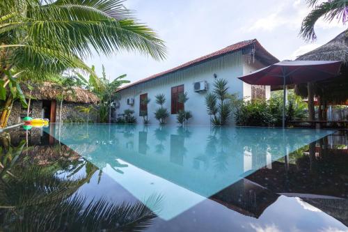 a swimming pool in front of a house with a building at Banyan Villa Nha Trang in Nha Trang