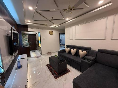 a living room with a black couch and a screen at sun vacation resort in Visakhapatnam