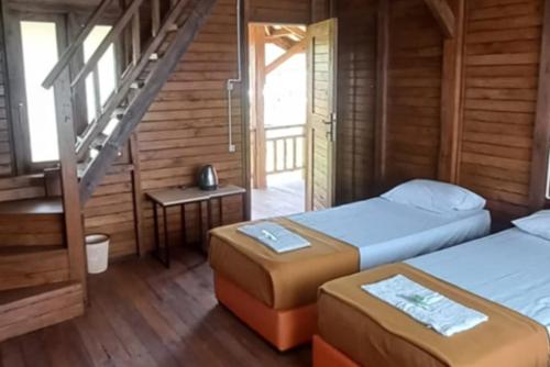 a room with two beds and a staircase in a cabin at Cozzy D'Sobahan Resort in Ngadirejo