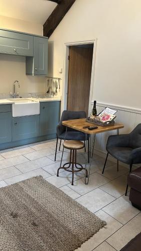 a kitchen with a table and chairs and a sink at Maes Madog Cottages in Betws-y-coed