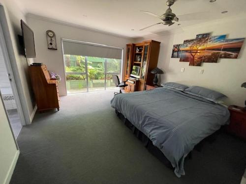 a bedroom with a bed and a large window at Lang's Beach Luxury Apartment in Langs Beach