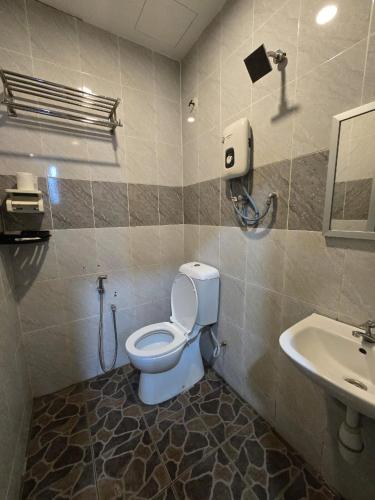 a bathroom with a toilet and a sink at First In Hotel in Bandar Saujana Putra