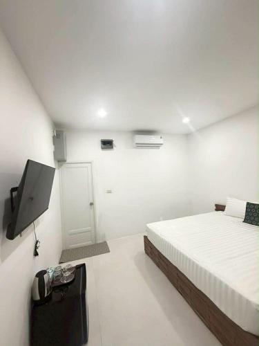 a bedroom with a bed and a flat screen tv at DD Bangrak Hotel in Koh Samui