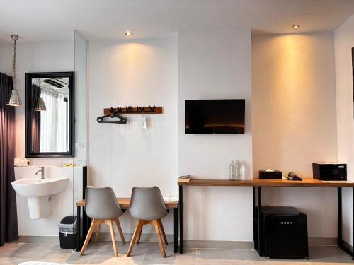 a bathroom with a sink and a table and chairs at i-river chiangmai in Chiang Mai