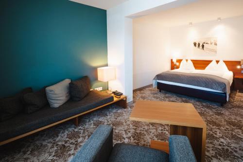 a hotel room with a bed and a couch at AlpenParks Hotel Maria Alm in Maria Alm am Steinernen Meer