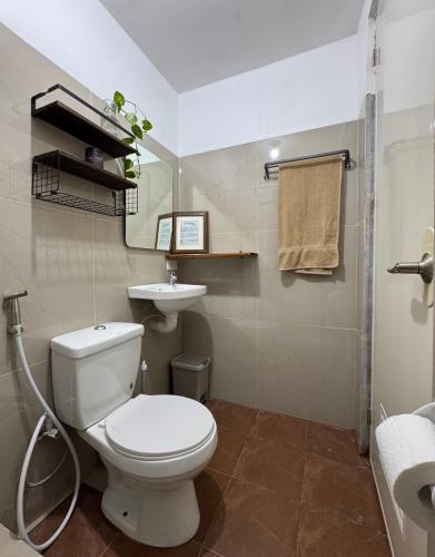 a bathroom with a white toilet and a sink at Ohana Trining in General Luna