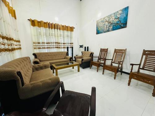 a living room with couches and chairs and a table at Ehana holiday in Tangalle