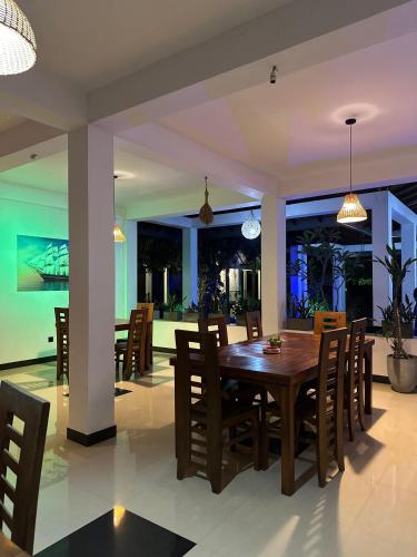 a dining room with a wooden table and chairs at Greenfield Haven in Polonnaruwa