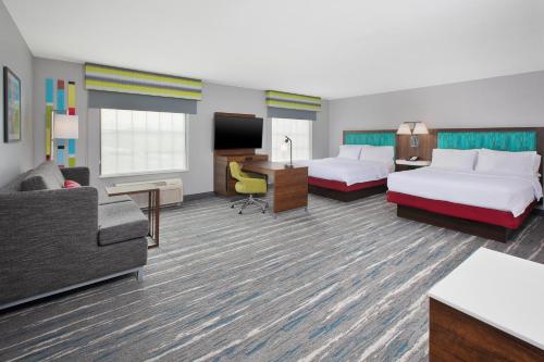 a hotel room with two beds and a couch at Hampton Inn and Suites St. Cloud in Saint Cloud