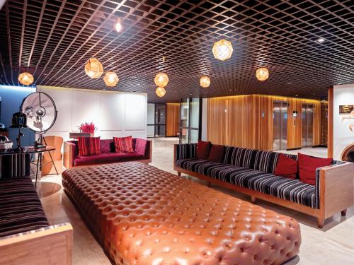 a living room with a large couch and red furniture at DoubleTree by Hilton Sukhumvit Bangkok in Bangkok