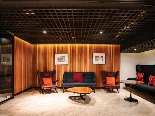 a room with a couch and chairs and a table at DoubleTree by Hilton Sukhumvit Bangkok in Bangkok
