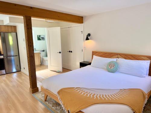 a bedroom with a large bed and a bathroom at Tofino Trailhead in Tofino