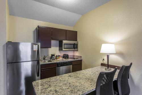 a kitchen with a refrigerator and a table with chairs at MainStay Suites Brentwood-Nashville in Brentwood