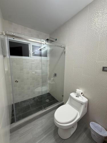 a bathroom with a toilet and a glass shower at Edificio Z7 in San Pedro Sula