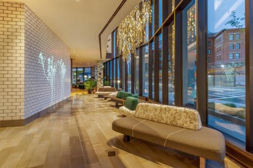 a lobby with couches and windows in a building at Cambria Hotel Boston Downtown - Seaport in Boston