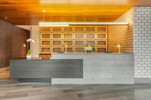 a lobby with a reception desk and a brick wall at Cambria Hotel Boston Downtown - Seaport in Boston