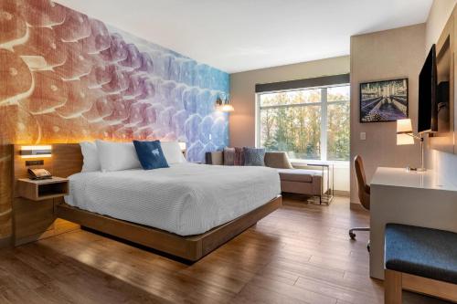 a hotel room with a bed and a couch at Cambria Hotel Manchester South Windsor in South Windsor