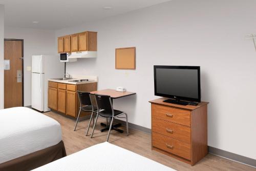 a room with a bed and a desk with a television at WoodSpring Suites Killeen in Killeen