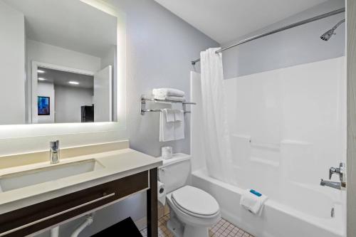 a bathroom with a sink toilet and a mirror at MainStay Suites Greensboro in Greensboro