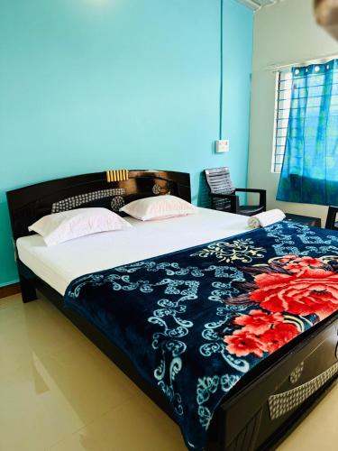 a bedroom with a bed with a blue and white comforter at Junglee tree stays in Hampi