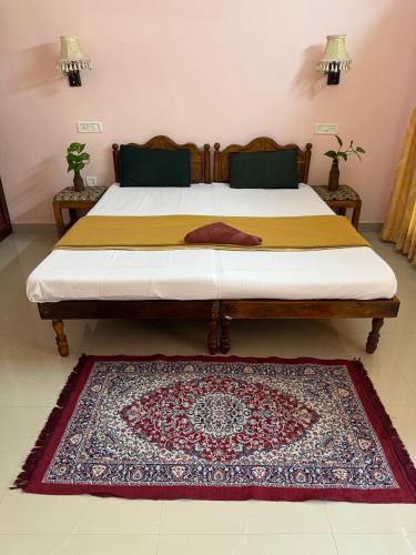 a bedroom with a bed with a rug on the floor at Hotel Cocobeach Kovalam in Kovalam