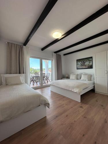 a bedroom with two beds and a balcony at Apartments Vukovic in Selce